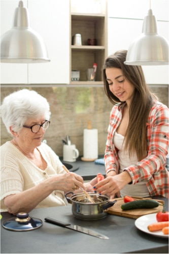 Woman assisting senior woman with cooking
