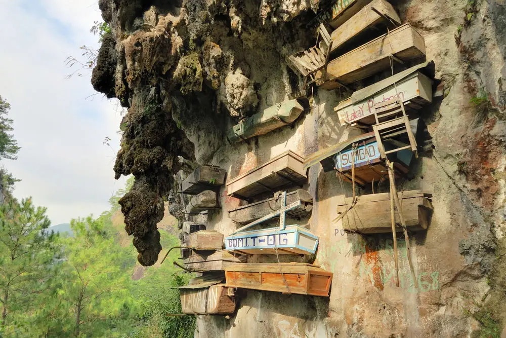 Series of rows of coffins hanging on the side of a mountain