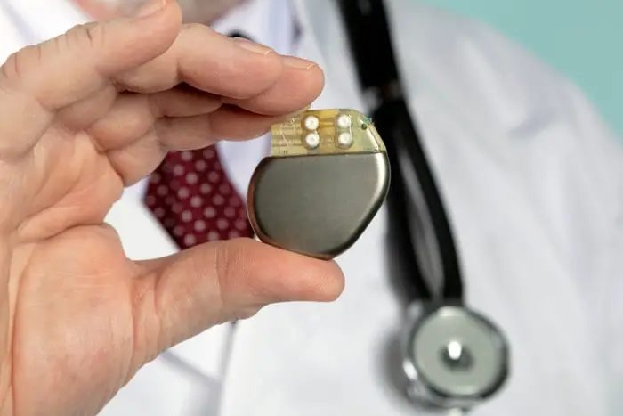 Close up of doctor's hand holding a medical implant device