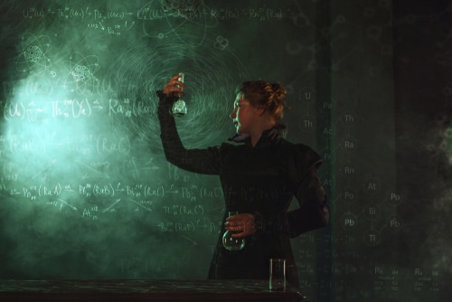 Illustration of female researcher holing up and looking at a flask there are equations on a chalkboard in the background