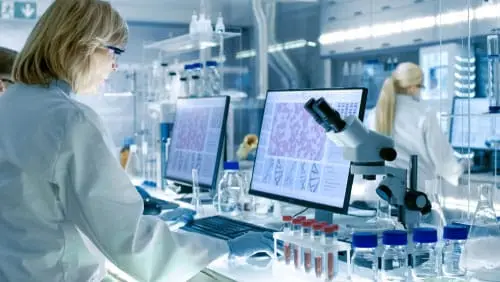 Rear view of two female researchers working in a modern lab