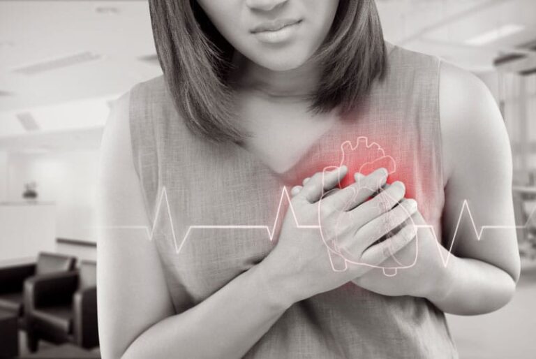 Woman with heart problem placing hands over her heart