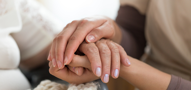 Caregiver holding patients hands