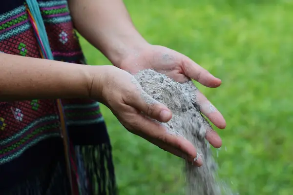 Close up of a woman's hands slowly releasing ashes